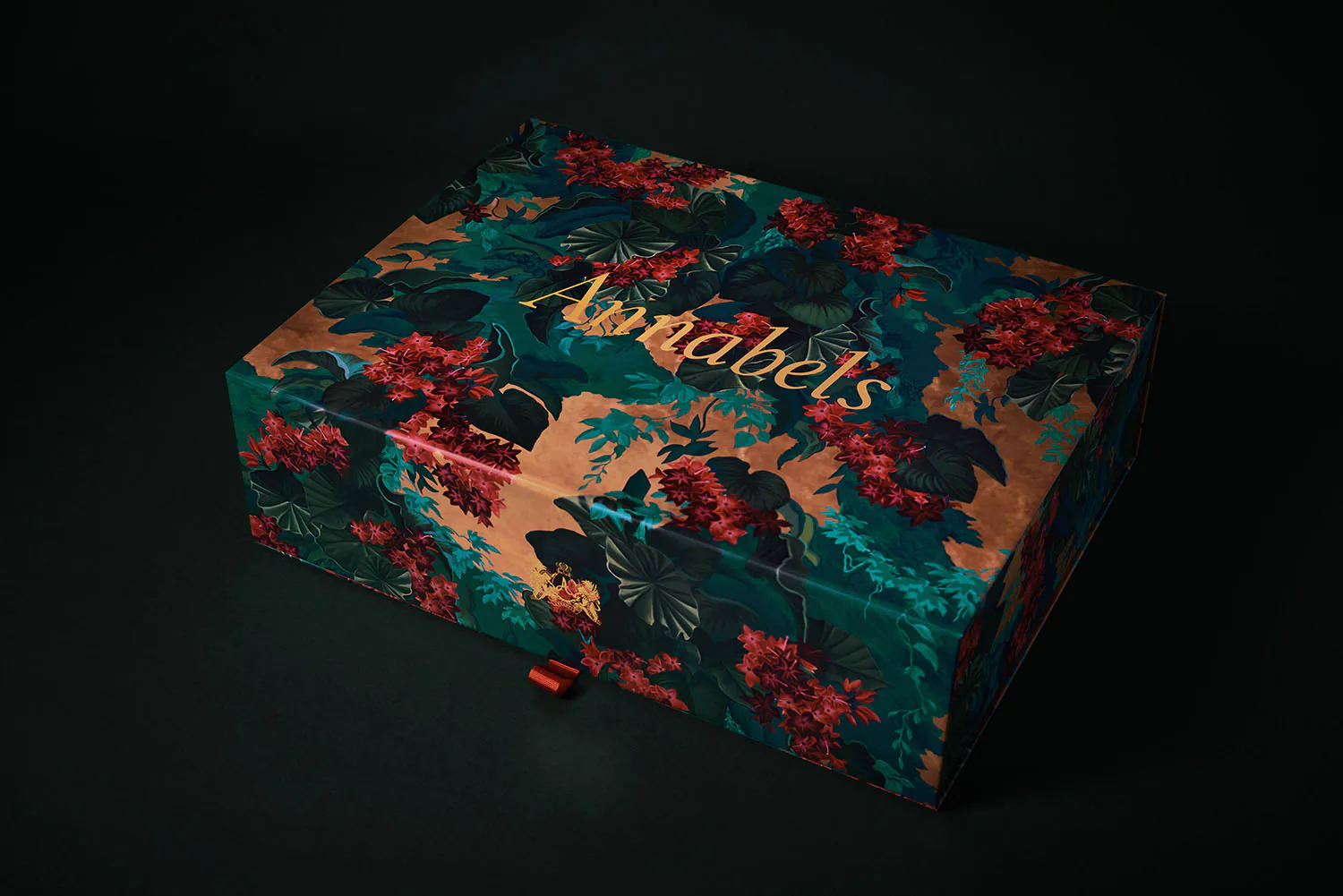 An Annabel's gift box in teal, printed with red and gold flowers and the name in gold.