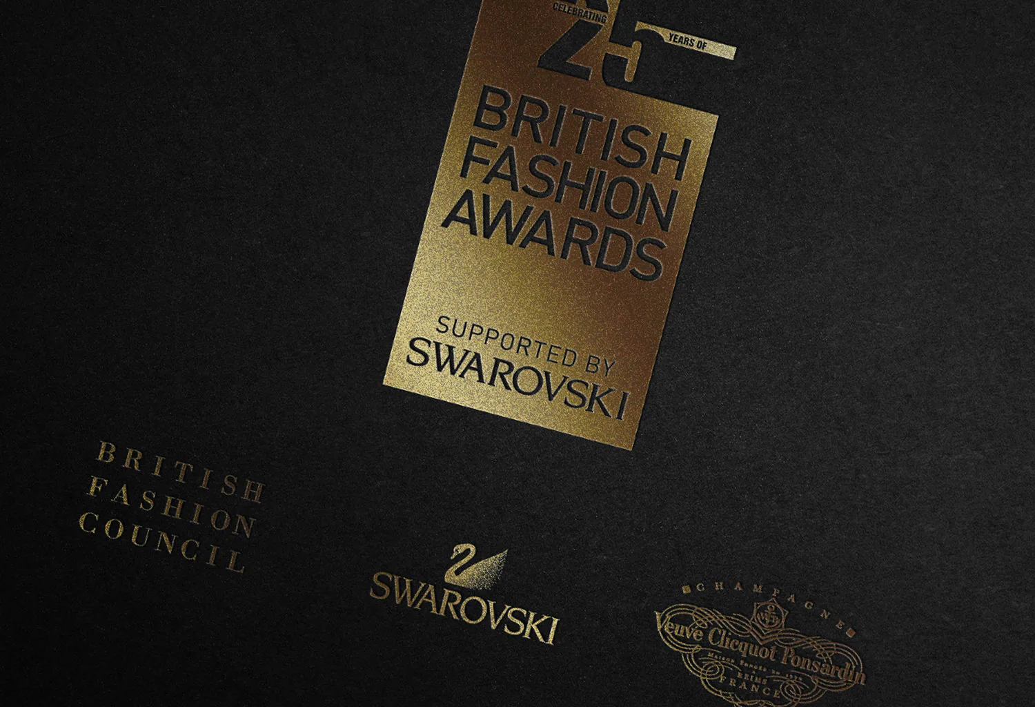 The British Fashion Awards identity in gold on black board, with the Swarovski lockup.