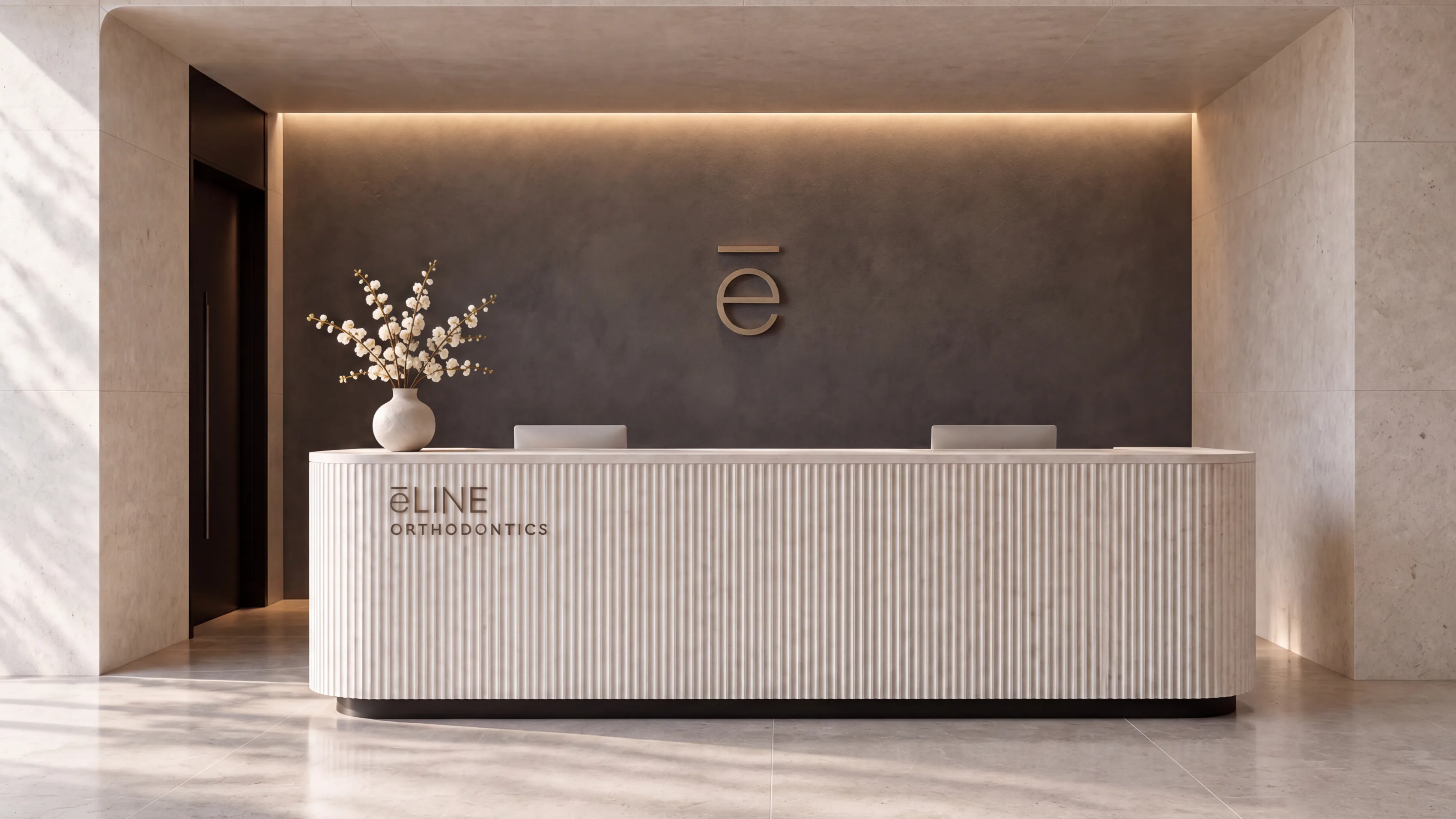 e-LINE Orthodontics reception desk in fluted stone with a bronze logo