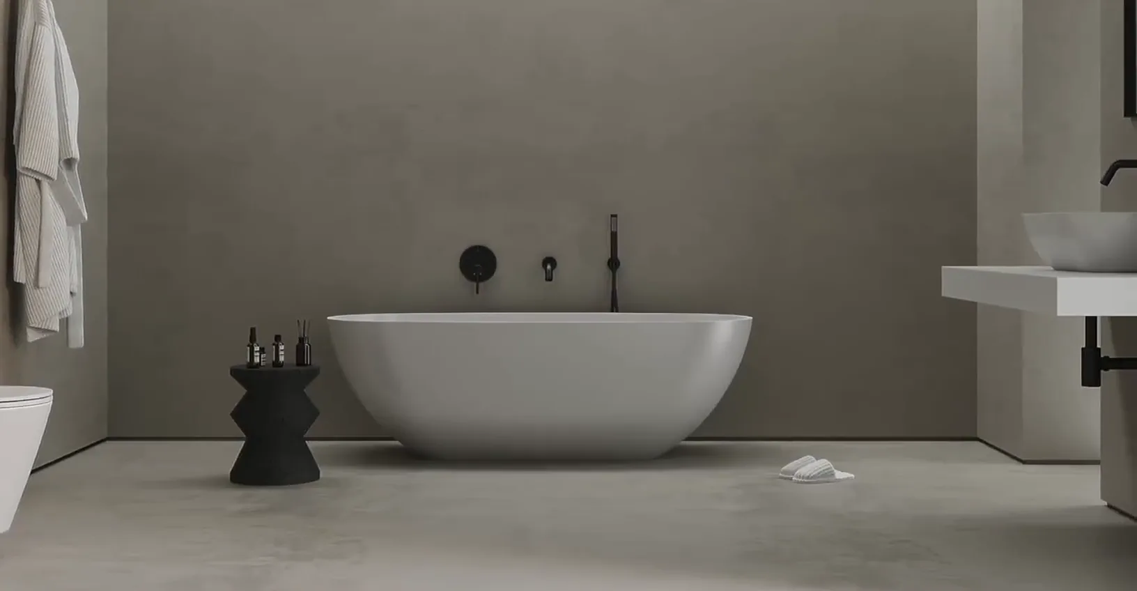 A slow pan across a grey plaster bathroom, white bath and basin with black taps.
